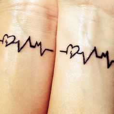 two wrist tattoos with heartbeats on them