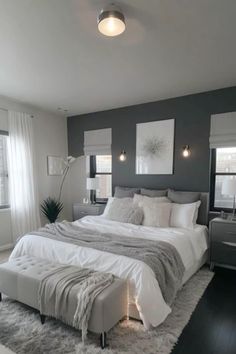 a large white bed sitting in a bedroom on top of a hard wood floored floor