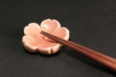 two chopsticks resting on a flower shaped object