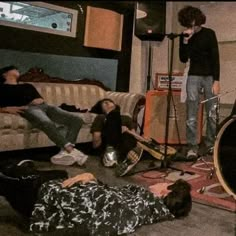 a group of people sitting in a living room next to each other on the floor