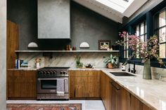 a kitchen with an oven, sink and counter tops in wood grained finish to the walls