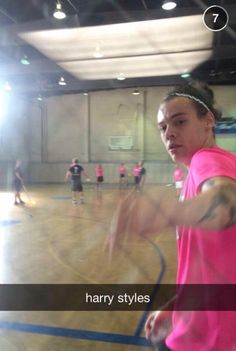 a woman in pink shirt holding a tennis racquet