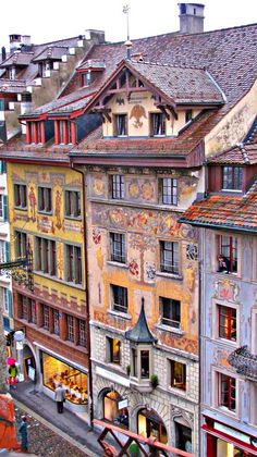 an aerial view of some buildings and people walking down the street in front of them