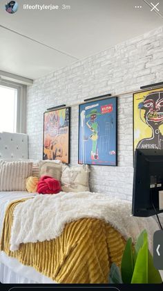 a bedroom with white brick walls and posters on the wall