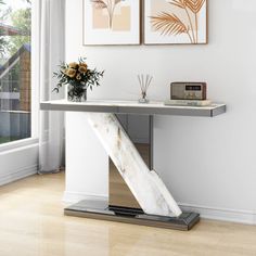 a modern console table with two pictures on the wall