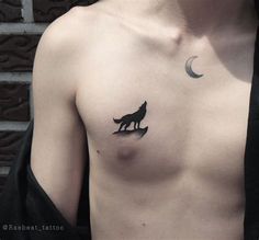 a man's chest with a wolf and moon tattoo on his left side shoulder