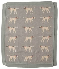 a gray blanket with brown and white dogs printed on the front, along with red collars