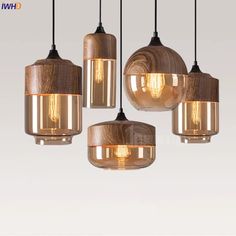 four light fixtures hanging from a ceiling with wood and glass shades on the bottom, one is