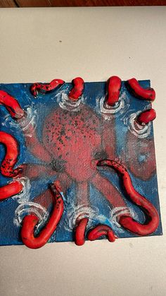 an octopus made out of plastic sitting on top of a blue and red table cloth