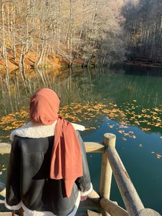 a person sitting on a bench looking at the water