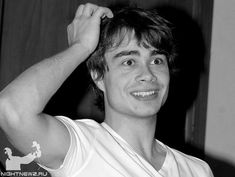 black and white photograph of a young man holding his hair in front of his face