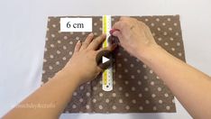 someone is measuring the width of a piece of fabric with a ruler on top of it