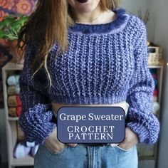 a woman wearing a blue sweater holding a sign that says grape sweater crochet pattern