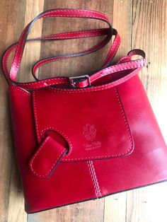 The spectacular stitching, magnetic clasp and deep rich color make this handbag a standout. The wide bottom makes this quite a roomy handbag at 9.5 inches long by 7.5 inches high. The zip closure adds extra protection. Stamped “Vera Pelle” - signifying genuine Italian leather & made in Italy. #leathershoulderbag #leatherhandbags #leatherhandbagswomen #leatherhandbagpurse #leathercrossbodybag #leatherpurses #verapelle Leather Flap Bag With Magnetic Closure For On-the-go, Leather Flap Bag With Detachable Strap, Chic Flap Bag With Cell Phone Pocket, Crossbody Satchel With Magnetic Closure, Chic Leather Bag With Cell Phone Pocket, Red Leather Flap Bag With Magnetic Closure, Flap Bag With Cell Phone Pocket For On-the-go, Everyday Bags With Magnetic Closure, On-the-go Flap Bag With Cell Phone Pocket