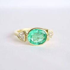 Item Details: 2.43 ct. natural Colombian Emerald vibrant light green color. Six round brilliant-cut diamonds weighing 0.06 ct (F/VS) Two trillion-shaped diamonds weighing 0.82 ct. (E/VS) Set in 18K yellow gold This ring is made with a one-of-a-kind center stone. To create a similar ring email custom@berlingerrings.com. Enquire about this ring Design a custom piece with us Trillion Diamond Ring, Trillion Diamonds, Antique Stone, Plastic Ring, Colombian Emeralds, Round Brilliant Cut Diamond, Brilliant Cut Diamond, Round Brilliant, Green Color