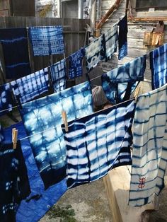 some blue and white towels hanging on a clothes line with one person looking at them