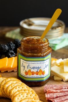 a jar of orange jam surrounded by cheese and crackers