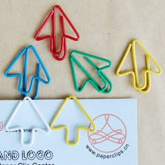 several colored paper clips sitting on top of a piece of paper