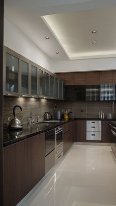 a modern kitchen with stainless steel appliances and dark wood cabinets, along with white flooring