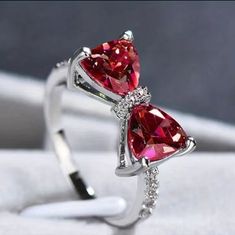 two heart shaped red diamond rings with diamonds on them