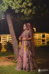 a woman standing in front of a tree at night