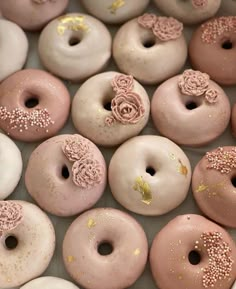 there are many donuts with pink frosting and gold sprinkles