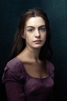 a woman in a purple dress is posing for a portrait with her hair pulled back