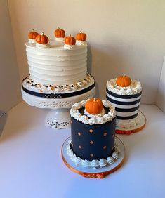 three tiered cakes with white frosting and orange pumpkins on top, all decorated in black and white