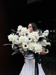 a woman holding a bouquet of white flowers