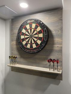 a dart board mounted to the side of a wall with darts in front of it