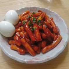 an egg is sitting on top of some food in a white bowl with red sauce