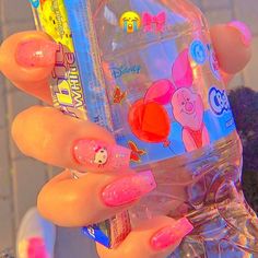 a person holding a plastic water bottle with pink and blue designs on it's fingers