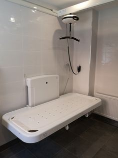 a white bath tub sitting next to a shower head mounted on the side of a wall