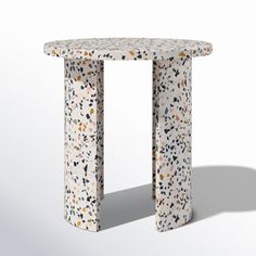 a white table with black and brown speckles on the top, sitting in front of a white background