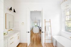 a bathroom with white walls and wood floors