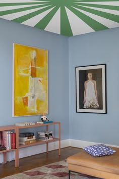 a living room filled with furniture and paintings on the wall above it's coffee table