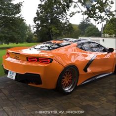 an orange sports car parked in front of a house