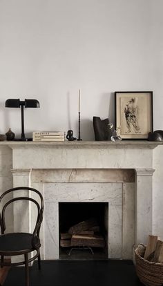 a room with a fireplace, chair and pictures on the mantle