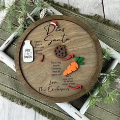 a wooden plaque with some cookies and carrots on it, sitting on a table