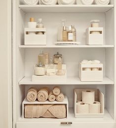 the shelves in this bathroom are filled with different types of towels and soaps on them