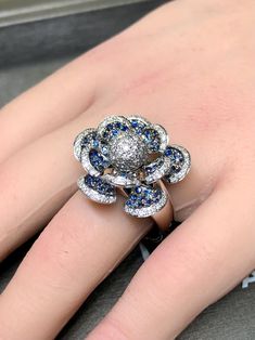 A whimsical contemporary ring done in 14K white gold and pave set with approximately 1cttw in H-I color Vs2-Si1 clarity round diamonds as well as 2cttw in blue sapphires. All petals articulate independently. Dimensions/Weight: Ring measures .95" in diameter and weighs 14.3g. Size 10.25 (sizable). Condition: All stones are secure and in perfectly wearable condition. R-T Petal Flower, Contemporary Ring, Cocktail Ring, Cocktail Rings, Pave Diamonds, Rings Statement, White Gold Diamonds, Blue Sapphire, Round Diamonds