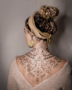 a woman with tattoos on her back and neck