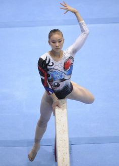 a woman is doing gymnastics on the balance bars