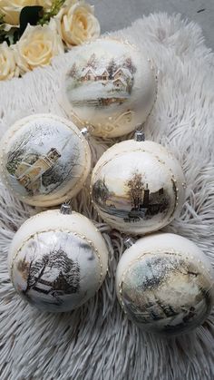 four white ornaments with trees on them sitting on a furnishing area next to flowers