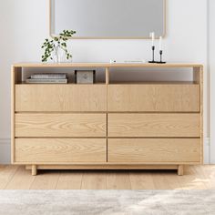 a wooden dresser with a mirror above it