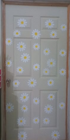 a white door with yellow and white flowers painted on the front part of it's frame