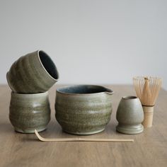 three ceramic bowls and two bamboo sticks on a table