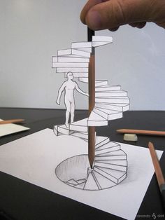 a person is drawing a spiral staircase with pencils