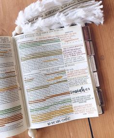 an open bible on top of a wooden table