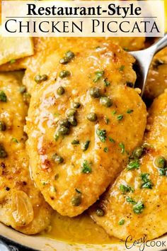 a close up of chicken with lemon and capers in a sauce on a plate